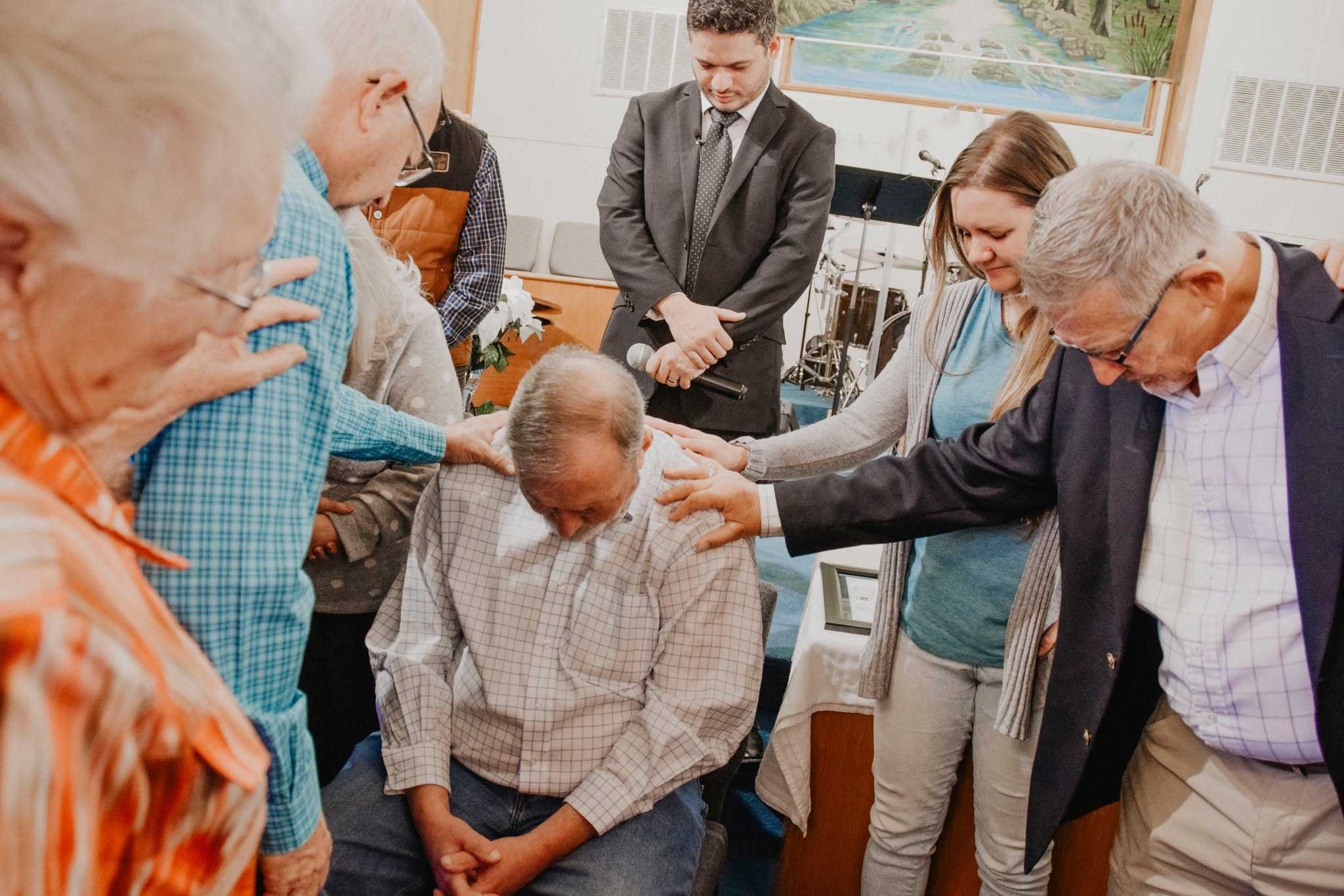 Church leaders surrounding a member in prayer